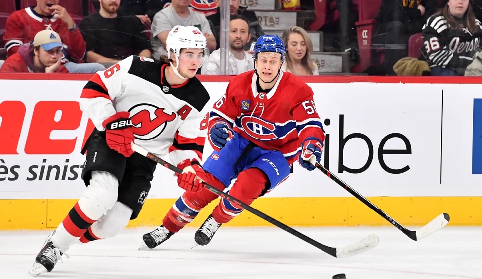 Montreal Canadiens' Alex Newhook (15) checks New Jersey Devils' Max Willman  (46) into the boards during first-period preseason NHL hockey game action  in Montreal, Monday, Sept. 25, 2023. (Christinne Muschi/The Canadian Press